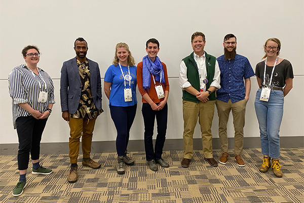 A group of 7 people stand for a photo.