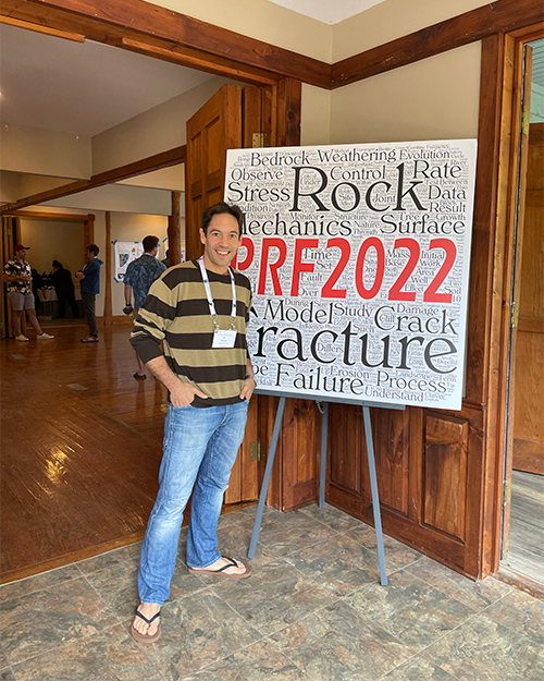 A man stands by a poster that reads 'PRF2022.'