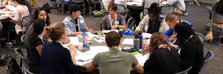 A group of people sit at a round table and converse at a GSA Annual Meeting.