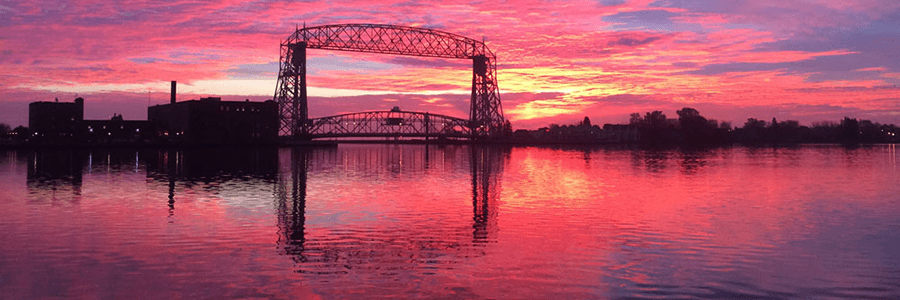 Duluth's Aerial Lift Bridge seen against a pink sunrise.
